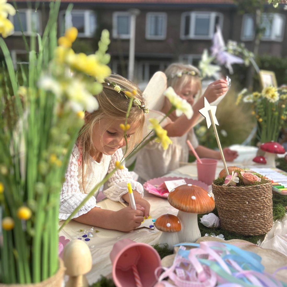 Meisje met een bloemenkrans knutselt aan de versierde picknicktafel, tussen de narcissen en paddenstoelen