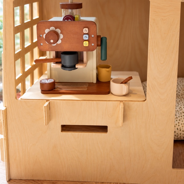 Speelgoed koffiezetapparaat op het loketje van het speelhuisje