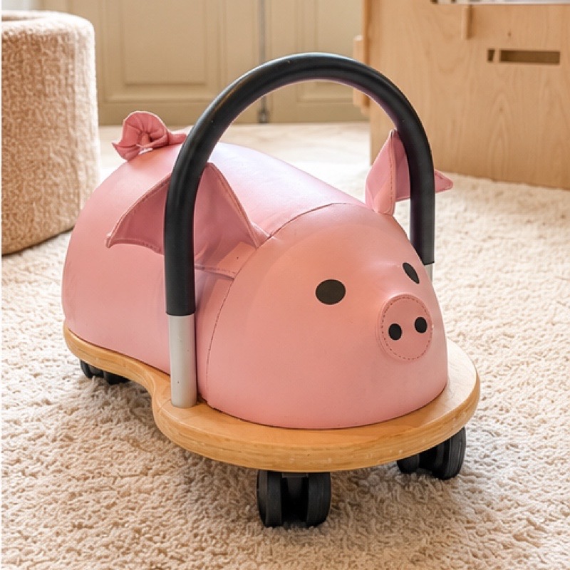 Roze loopautootje in de vorm van een varkentje, voor het speelhuisje