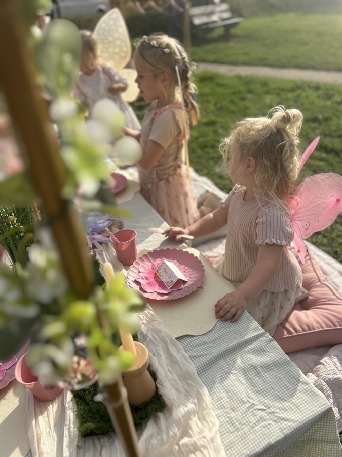 Kinderen knielen op de kussens langs de picknicktafel