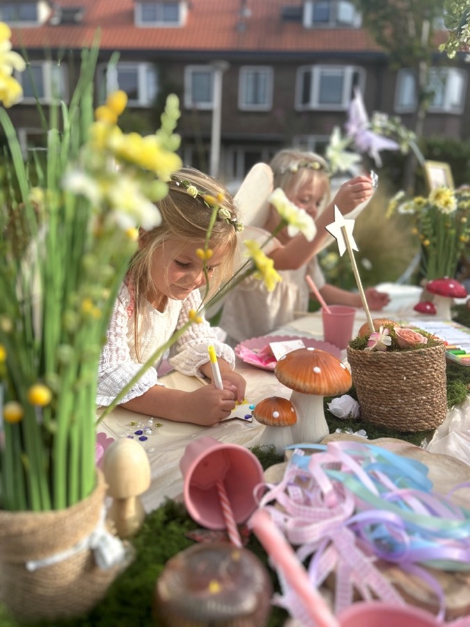 Meisje met een bloemenkrans knutselt aan tafel, tussen de narcissen